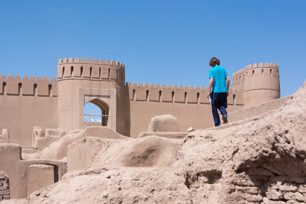 Boy walking on the wall at Arg-e Rayen citadel near Kerman, Iran