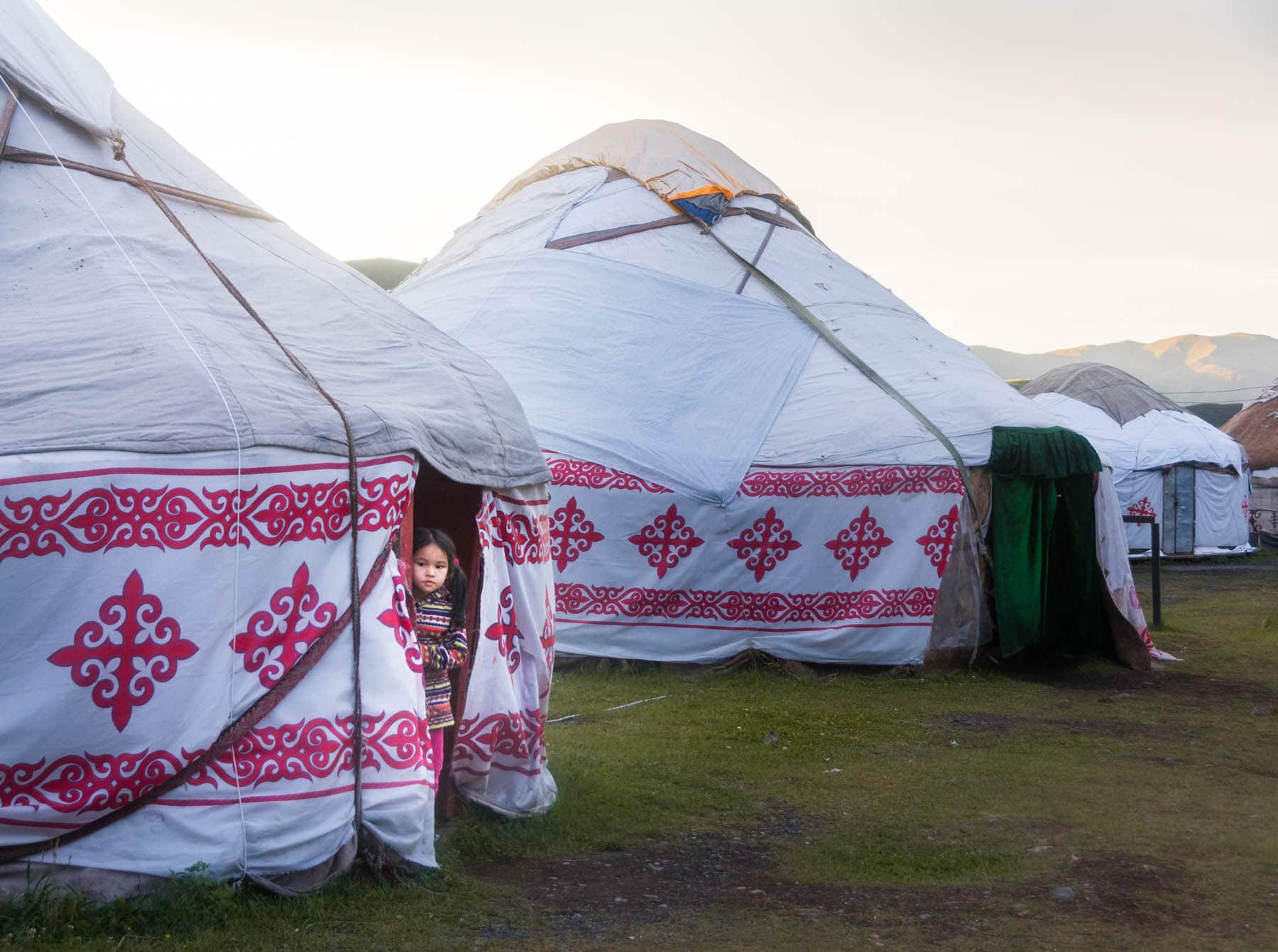 A girl peeking out from the yurt camp at Kolsai, Kazakhstan - Lost With Purpose
