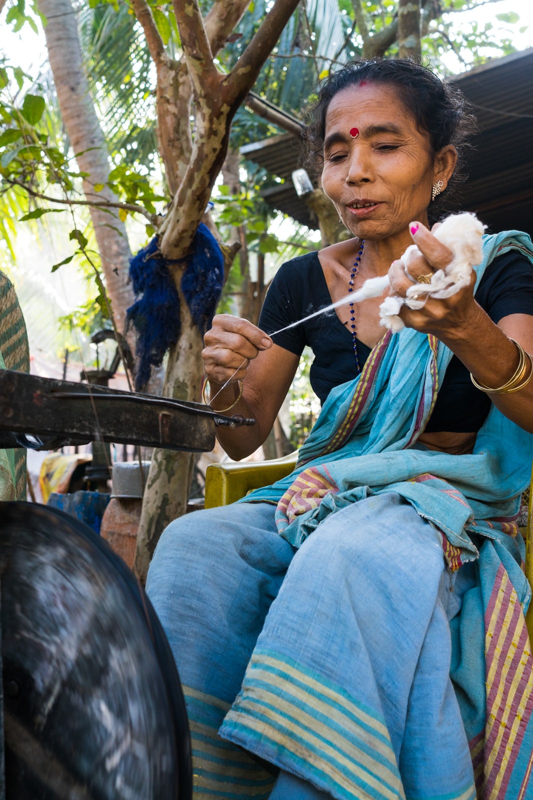 A local woman spinning thread in Assam, India.