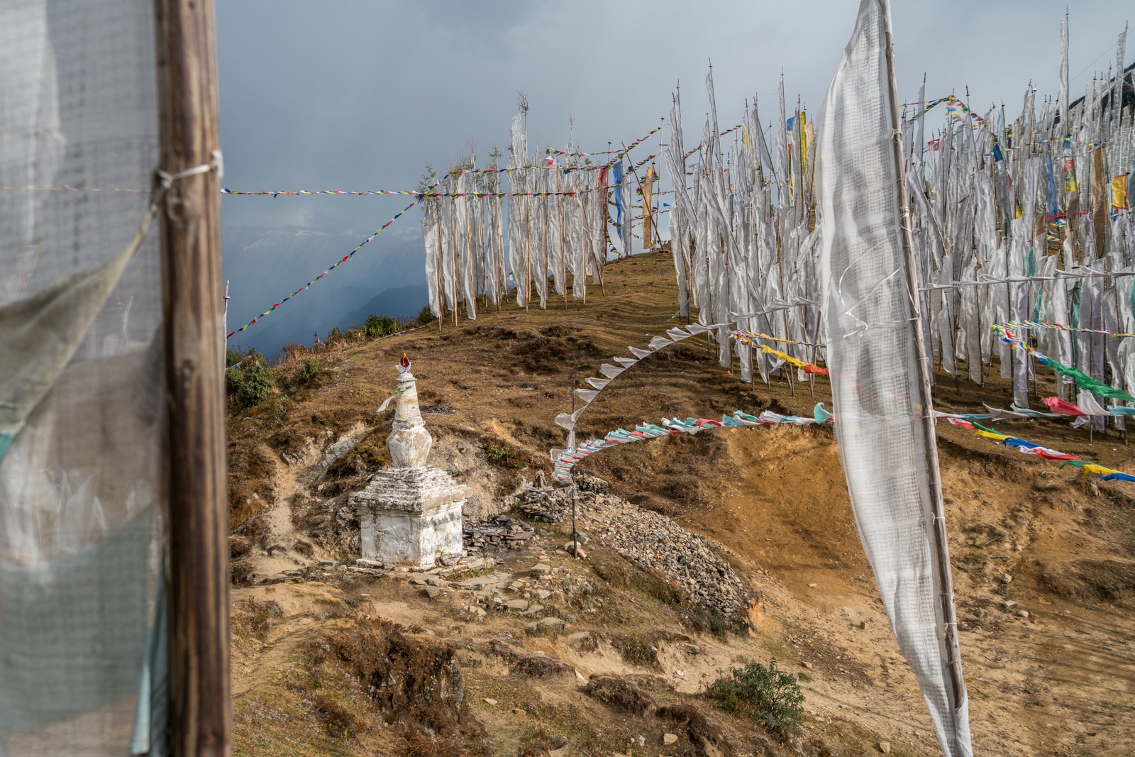 White prayer flags and a small stupa on Chele La mountain pass