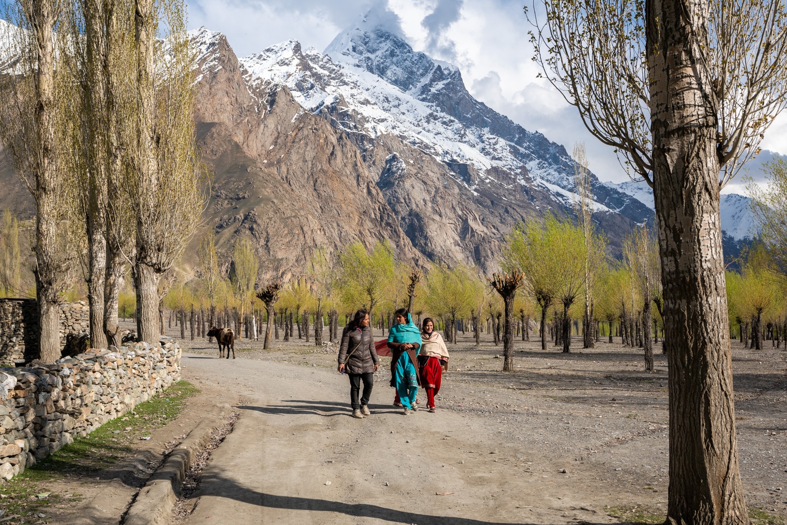 Tourist walking with local women in Darkot, Yasin Valley, Pakistan