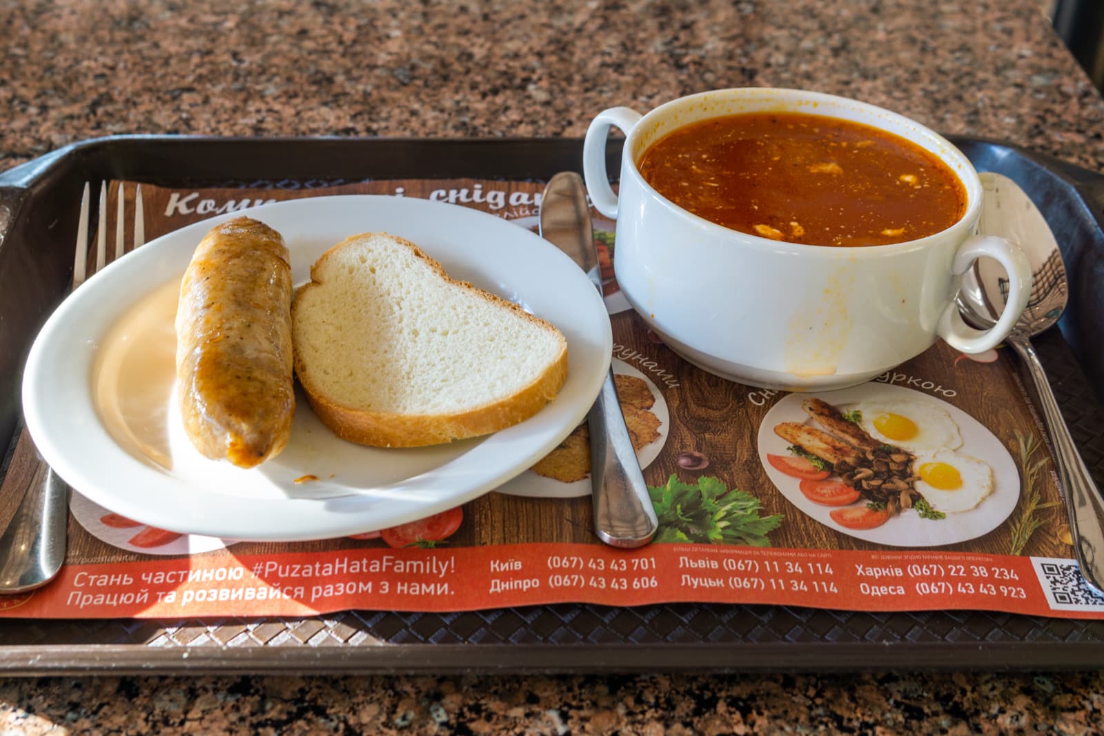 A typical cafeteria meal in Ukraine with sausage and borsch and bread