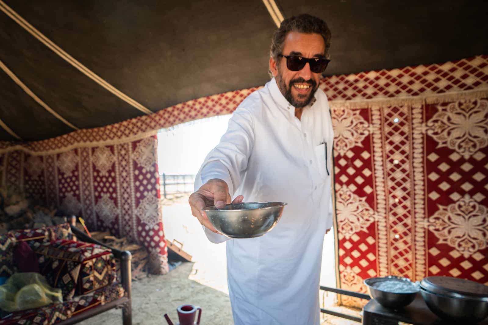 Saudi man offering a bowl of fresh camel milk